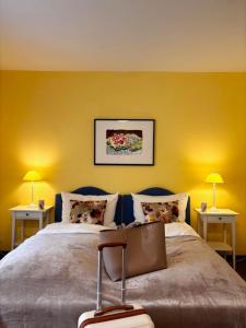a bedroom with two beds with yellow walls and two lamps at Hotel Finkenhof - Haus Finkenhof in Hannover