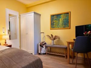 a bedroom with a bed and a desk and a television at Hotel Finkenhof - Haus Finkenhof in Hannover