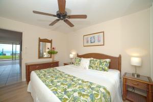 a bedroom with a bed and a ceiling fan at Kulakane 105 · KK105 Sunsets Ocean Views Oceanfront in West Maui in Kahana +42 photos