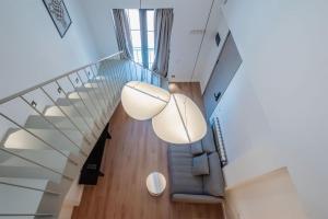 トビリシにあるArtifact Apart Hotelのガラスの手すりと青いソファのあるオープン階段