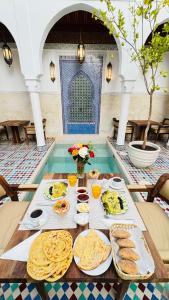 einen Tisch mit Essen in einem Pool in der Unterkunft Riad du Rabbin in Marrakesch