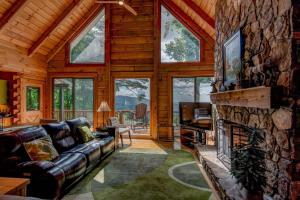 a living room with a stone fireplace in a log cabin at 1 Sublime View in Boone