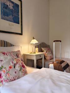 a bedroom with a bed and a table with a lamp at Hotel Finkenhof - Haus Finkenhof in Hannover