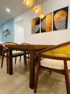 une salle à manger avec une table et des bancs en bois dans l'établissement Galle Fort View Luxury Apartment, à Galle