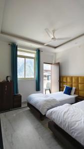 a bedroom with two beds and a window at Hotel Yoga Stay Rishikesh in Rishīkesh +28 photos
