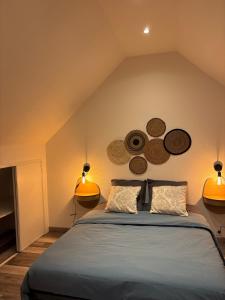 a bedroom with a bed with two lights on the wall at Gîte du Haut-Plantais in Saint-Aubin-de-Terregatte