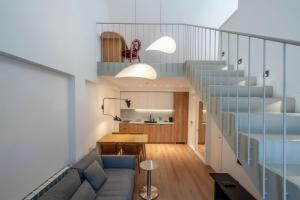a living room with a couch and a staircase at Artifact Apart Hotel in Tbilisi City +102 photos