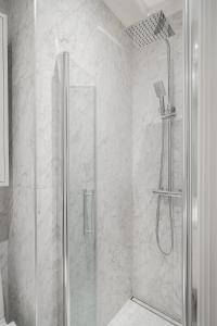 スンドビュベリにあるStylish 2BR Apartment in Central Sundbybergの浴室のガラス扉付きシャワー