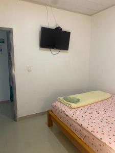 een slaapkamer met een bed en een tv aan de muur bij Hotel Boutique 51 in Barrancabermeja