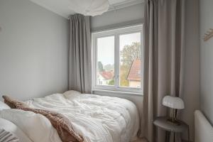 スンドビュベリにあるStylish 2BR Apartment in Central Sundbybergのベッドと窓のある白い寝室
