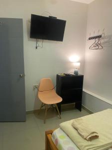 een slaapkamer met een bed, een bureau en een stoel bij Hotel Boutique 51 in Barrancabermeja