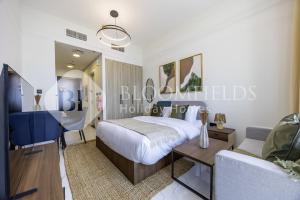 Un dormitorio con una cama, una mesa y un sofá. en Bloomfields EcoGate Stu Masdar City, en Abu Dhabi Intl