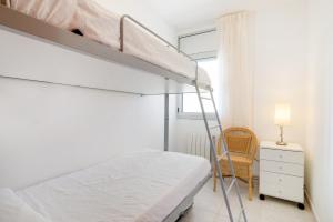 a bedroom with a bunk bed and a chair at Apartaments Ancora in Palamós +25 photos