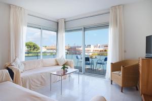 a living room with a couch and a large window at Apartaments Ancora in Palamós