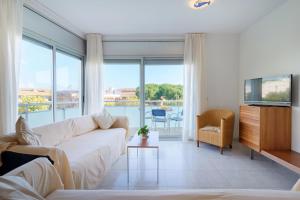 a living room with a white couch and a television at Apartaments Ancora in Palamós