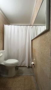 a bathroom with a toilet and a shower curtain at Cayenne Cozy Apt with Generator and Cistern in Bayamon in Sierra Linda