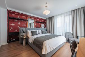 a bedroom with a large bed and a red wall at Artifact Apart Hotel in Tbilisi City +86 photos