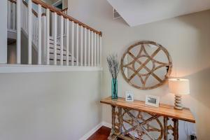 a hallway with a table with a lamp and a staircase at Fairway Oasis in Hilton Head Island