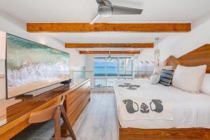 a bedroom with a large tv and a bed at Napili Point C3 · NP C3 Renovated OceanFront to Whale Watch Rela in Kahana