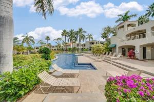 a resort pool with lounge chairs and palm trees at Palms at Wailea 2108 · PAW 2108 Remodeled Wailea Condo w AC Infi in Wailea