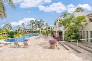 a pool at a resort with chairs and palm trees at Palms at Wailea 2108 · PAW 2108 Remodeled Wailea Condo w AC Infi in Wailea