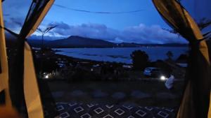 a view from the inside of a tent looking out at a lake at Adelisca Glamping, Cafe and Villa in Kubupenlokan