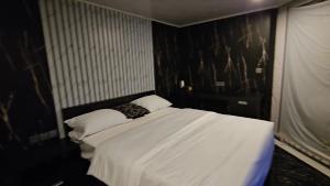 a bedroom with a bed with white sheets and pillows at Adelisca Glamping, Villa and Cafe in Kubupenlokan