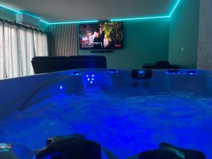 a hot tub in a room with a tv at bulles et détente in Seuil