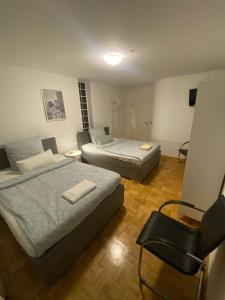 メルフェルデン・ヴァルドルフにあるWesternのベッド2台と椅子が置かれた寝室