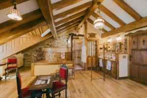 an attic room with wooden ceilings and a table and chairs at Prada a Tope - Palacio de Canedo in Canedo
