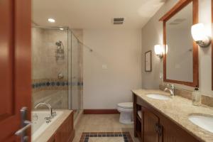 a bathroom with two sinks and a shower and a toilet at Deluxe Ski in-out - HotTub - Fire - PingPong - View in Mont-Tremblant +59 photos