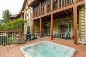 a house with a hot tub on a patio at Deluxe Ski in-out - HotTub - Fire - PingPong - View in Mont-Tremblant