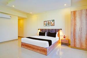 a bedroom with a large bed in a room at Hotel O Indian Suites in Bengaluru