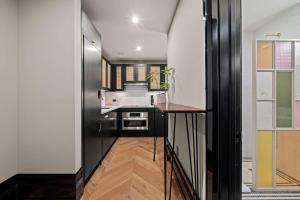 a kitchen with a black refrigerator and a sink at Freeman 303 by Rove - 1BR Condo with Shared Amenities in New York
