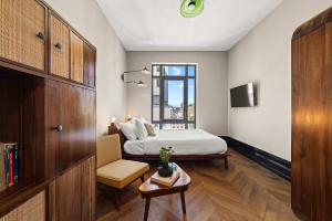 a bedroom with a bed and a chair and a window at Freeman 303 by Rove - 1BR Condo with Shared Amenities in New York