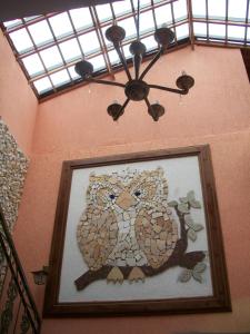 a picture of an owl hanging on a wall at Pousada Canto das Corujas in São Roque