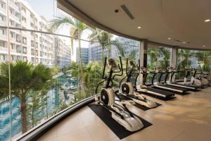 a gym with rows of tread machines in a building at Dusit Grand Park - Modern Studio Pool View in Jomtien Beach
