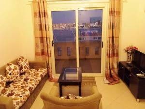 a living room with a couch and a large window at The Horizon House in Luxor