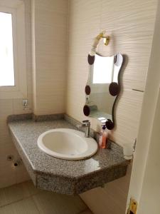 une salle de bain avec un lavabo et un miroir dans l'établissement The Horizon House, à Louxor 3 autres photos