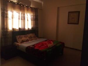 Ce lit se trouve dans une chambre dotée d'une fenêtre éclairée. dans l'établissement The Horizon House, à Louxor