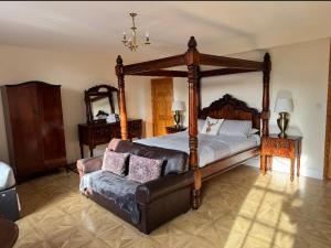 SpilsbyにあるWhite Hart Hotelの大きなベッドとソファのある寝室