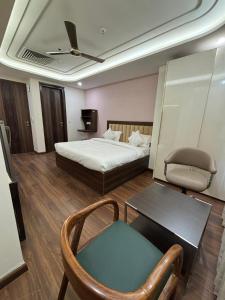 Un dormitorio con una cama, una silla y una mesa. en QuickIn Stayz managed by The AIKaya Hotels, en Gurgaon