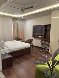 Un dormitorio con una cama y un televisor de pantalla plana. en QuickIn Stayz managed by The AIKaya Hotels, en Gurgaon 16 fotos más