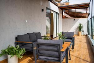 a patio with chairs and a wooden table at Duplex Moderno y Espacioso en Miraflores in Lima