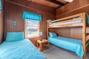 two bunk beds in a room with wooden walls at Sun Byrne - K1060 in Whalebone