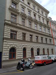 un furgone e una moto parcheggiati di fronte a un edificio di Ableidinger Apartments a Vienna