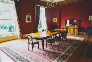 a dining room with a wooden table and chairs at Ballynacree House and Cottages in Balnamore +18 photos