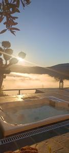 een hottub midden in een veld met de zonsondergang bij Casinha Serabigoes Arouca Passadiços Paiva in Arouca