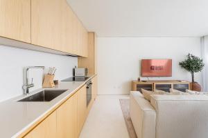 una cocina con fregadero y un sofá en GuestReady - DPV GuestHouse - Apart 6, en Oporto 37 fotos más
