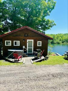 a log cabin with a table and chairs in front of a lake at Winter at Wildwood in Bailieboro